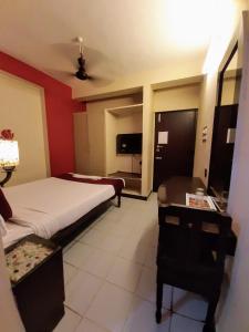 蓬蒂切里Ravi Krishna Inn的酒店客房配有两张床、一张书桌和一张四柱床。