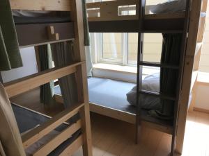 札幌Sapporo Guest House 庵 Anne的客房设有两张双层床和一扇窗户。