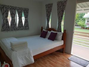 大城Baan Suan Yensabai @Ayutthaya的一间卧室配有一张带白色床单的床和一扇窗户。