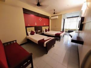 蓬蒂切里Ravi Krishna Inn的酒店客房,设有两张床和一张沙发