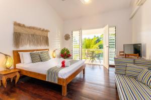 维拉港热带泻湖公寓式酒店的一间卧室配有一张床、一台电视和一张沙发