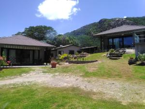 马埃岛Eco Lodge Self-Catering的一座房子,旁边是草地庭院