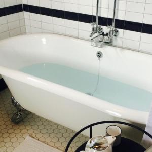RaweneMarriner's Boutique Guesthouses的瓷砖浴室设有白色浴缸。