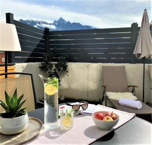 绍滕斯Easy Living Apartment Ötztal的一张桌子,上面有花瓶和一碗水果