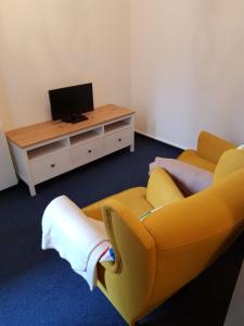 纽伦堡Apartments Blumenthal的客厅配有黄色沙发和电视