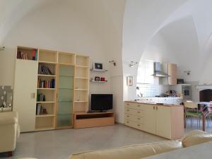 布林迪西La Casa Sul Porto的客厅设有厨房和电视。