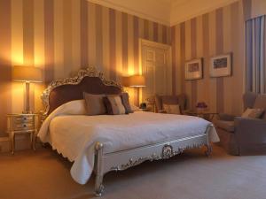 珀斯巴拉蒂斯之家酒店的一间卧室配有一张大床和两把椅子