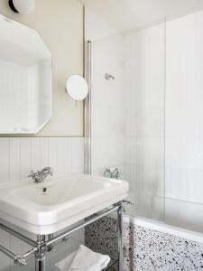 巴黎Hôtel Léopold - Orso Hotels的白色的浴室设有水槽和浴缸。