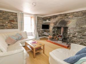 Isle of WhithornThe Pink House的客厅设有带壁炉的石墙