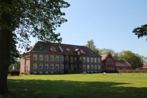 LudorfDas kleine, gemütliche Ferienhaus的一座大型红砖建筑,有大片草地