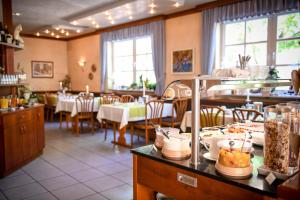 马尔克泰登费尔德Hotel Mainblick Garni的餐厅配有桌椅,柜台上提供食物