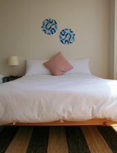 仁川市Treehouse的卧室内的一张带白色床单和枕头的床