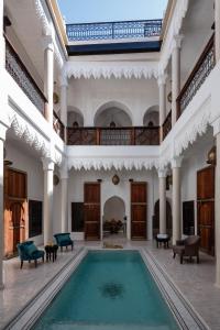 马拉喀什Riad Spice by Marrakech Riad的一座室内游泳池,位于一座带大楼的大房间内
