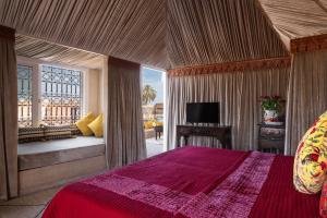 马拉喀什Riad Spice by Marrakech Riad的一间卧室配有红色的床和电视。
