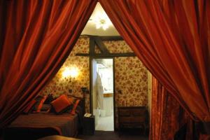 巴黎德尚帕涅大酒店的一间卧室配有红色窗帘、一张床和镜子