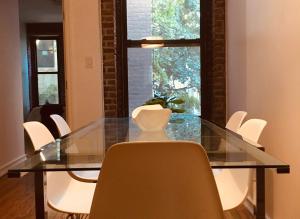 纽约Two Bedroom Harlem Apartment的一间设有玻璃桌和白色椅子的用餐室