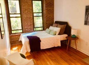 纽约Two Bedroom Harlem Apartment的一间卧室设有一张床和砖墙