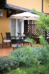豪伊杜索博斯洛托斯卡纳别墅酒店的庭院配有桌椅和遮阳伞。