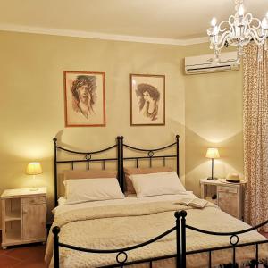 豪伊杜索博斯洛托斯卡纳别墅酒店的卧室配有一张床,墙上挂有两张照片