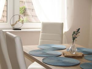 GösenrothHaus Mersche的一张带蓝色盘子的餐桌和花瓶