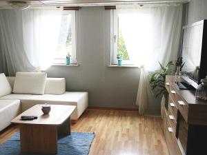 GösenrothHaus Mersche的客厅配有白色沙发和2扇窗户。