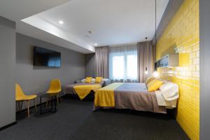 瓦伦西亚Nest Style Valencia的酒店客房带两张床和一张桌子以及椅子。