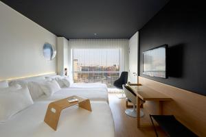 巴塞罗那桑特斯巴塞罗酒店的配有一张床和一张书桌的酒店客房