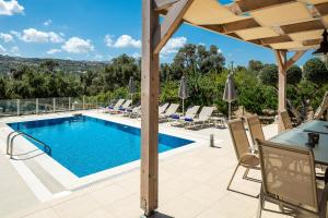 阿德里安诺斯坎波斯Villa Kalli Crete的庭院内的游泳池,配有桌椅