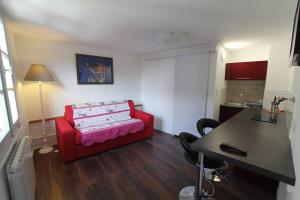 利克维Chambre chez l'habitant Le Rouge-Gorge - Cœur de Riquewihr - 2 personnes的客厅配有红色的沙发和桌子