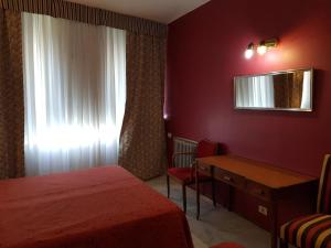 布宜诺斯艾利斯特雷斯萨根图斯酒店的一间卧室配有一张床、一张书桌和一个窗户。