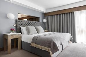 格拉斯哥Kimpton - Blythswood Square Hotel, an IHG Hotel的一间卧室设有一张大床和一个窗户。