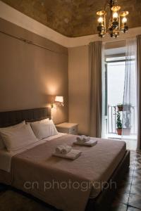 苏尔莫纳La Dimora del Falconiere - Luxury Suites的一间卧室配有一张床,上面有两条毛巾