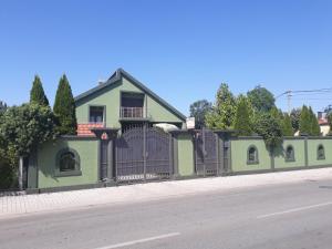 尼克希奇Apartments Delić的路边有栅栏的绿色房子