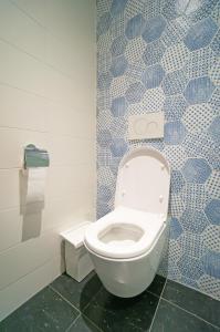 鹿特丹斯帕克斯旅舍的浴室设有蓝色和白色瓷砖,配有卫生间