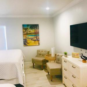 维洛海滩Sea Turtle Inn的一间卧室配有一张床、一台电视和一把椅子