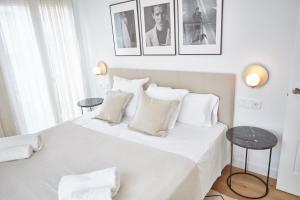 隆达Apartamentos La Bola Suite的白色卧室配有一张带白色床单和枕头的大床