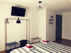 UdbinaArtisan House Meraki的卧室配有一张床,墙上配有电视。