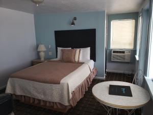 弗拉格勒海滩托帕汽车旅馆 - 弗拉格勒海滩 的酒店客房配有一张床铺和一张桌子。