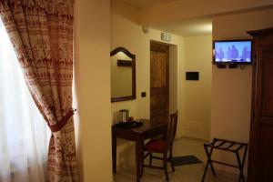 切萨纳·都灵尼斯奥林匹克山旅馆的配有桌子、镜子和电视的房间