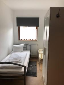 新勃兰登堡Pension ,,Vier Tore''的一间小卧室,配有床和窗户