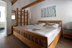 施洛斯霍尔特-斯图肯布罗克Komfort-Ferienwohnungen"Am Furlbach"的一间卧室配有一张大木床和白色床单
