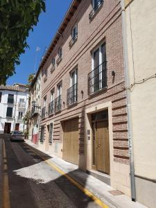 格拉纳达ecoSmart Apartments Granada的街道上设有两扇车库门的砖砌建筑