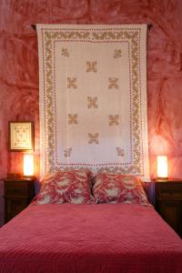 Carenas罗斯佩多加乐斯乡村民宿的一张带红色被子和两盏灯的床