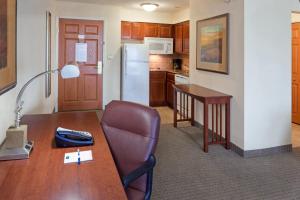 Royersford费城福吉谷422斯代布里奇套房酒店的厨房配有桌子、椅子和书桌