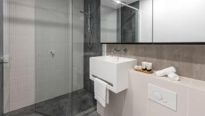 墨尔本Avani Melbourne Central Residences的白色的浴室设有水槽和淋浴。