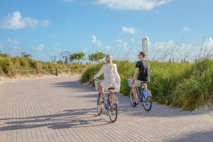 迈阿密海滩Ocean Beach Suites的骑着自行车的男人和女人
