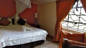 内罗毕奥索伊塔旅馆的一间卧室设有一张床和一个窗口