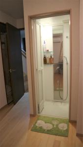 WaizumiSadie's Home的带淋浴的浴室和绿色地毯。