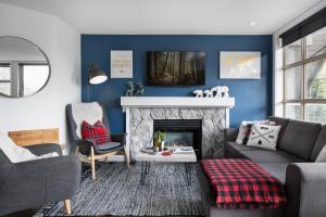 惠斯勒THE LOOKOUT PENTHOUSE // a luxe suite in Whistler的客厅设有蓝色的墙壁和壁炉。