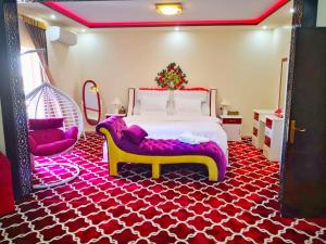 图赖夫Almudawah Hotel的一间卧室配有大床和红白色地毯